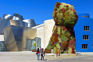 Tourists view Puppy flower feature floral art by Jeff Koons at Guggenheim Museum in Bilbao, Basque Country, Euskadi, Spain, Europe