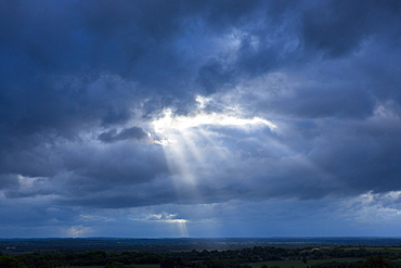 Rays of the sun break through cloudy stormy sky in inclement weather, England, United Kingdom, Europe