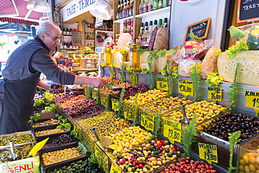 Shopkeeper with green and black olives for sale at food market in Kadikoy district on Asian side of Istanbul, Turkey, Asia Minor, Eurasia