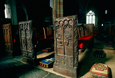 Ornate, ancient wooden carved pews and tapestry kneeling pads  in St. Keverne Parish Church in Cornwall, England