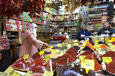 Woman shopper wearing Muslim veil buys spices in Misir Carsisi Egyptian Bazaar food and spice market, Istanbul, Turkey, Europe