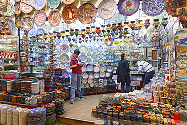 Man using smartphone in ceramics and souvenirs stall in The Grand Bazaar (Great Bazaar) (Kapali Carsi), Beyazi, Istanbul, Turkey, Europe