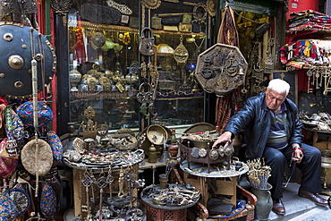 Shopkeeper with metal objects in antique shop in The Grand Bazaar (Great Bazaar) (Kapali Carsi), Beyazi, Istanbul, Turkey, Europe