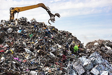 Grab machine organising metal recycling of scrap metal to avoid environmental pollution in England, United Kingdom, Europe