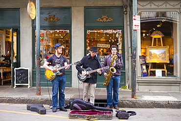 Jazz musicians saxophonist and guitarist in live busking performance on street corner in French Quarter, New Orleans, USA