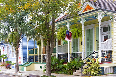 Traditional clapboard creole cottage home and stars and stripes flag in Faubourg Marigny historic district  of New Orleans, USA