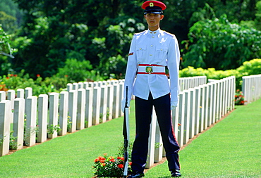 Soldier standing on guard over Commonwealth war graves at Krangi War Cemetery in Singapore