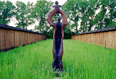 Majdanek Concentration Camp in Poland - memorial to victims of the Holocaust - a sculpture of an adult holding up a child.