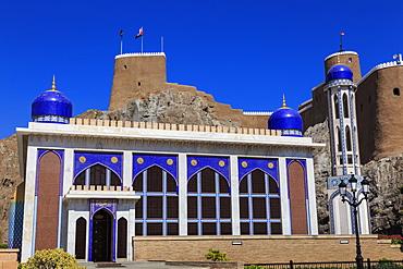 Blue domed mosque with minaret and Al-Mirani Fort, Old Muscat, Oman, Middle East