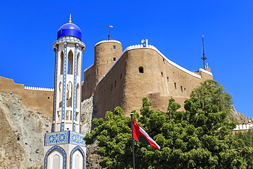 Blue domed mosque minaret, Oman, Middle Easti National Flag and Al-Mirani Fort, Old Muscat, Oman, Middle East