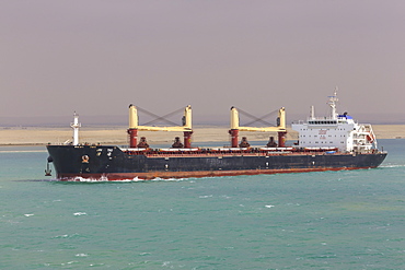 Ship transits the Suez Canal with sandy desert backdrop, Great Bitter Lake, near Ismalia, Egypt, Northeast Africa