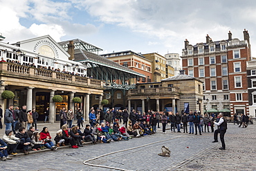 Juggler performs to a large crowd, Piazza and Central Market, Covent Garden, London, England, United Kingdom, Europe