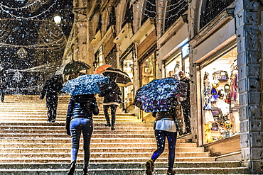 People on Rialto Bridge with umbrellas during rare snowfall, winter evening, Venice, UNESCO World Heritage Site, Veneto, Italy, Europe