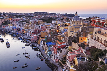 Marina Corricella, blue hour after sunset, fishing village, colourful houses, boats and church, Procida, Bay of Naples, Campania, Italy, Europe