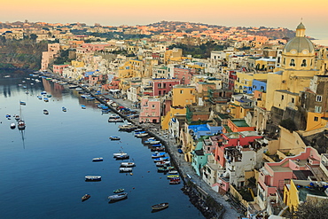 Marina Corricella at sunrise, fishing village, colourful houses, church and harbour boats, Procida Island, Bay of Naples, Campania, Italy, Europe