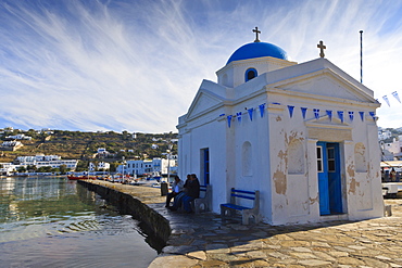 Three men on a seat beside an old harbour church, Mykonos Town (Chora), Mykonos, Cyclades, Greek Islands, Greece, Europe 