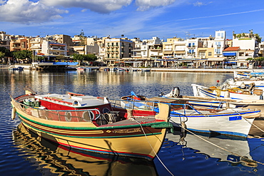 Small fishing boats reflected in Voulismeni Lake, Agios Nikolaos, Lasithi, Crete, Greek Islands, Greece, Europe