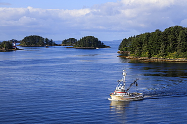 Commercial fishing boat and small forested islands, rare summer sun, Sitka Sound, Sitka, Baranof Island, Southeast Alaska, United States of America, North America