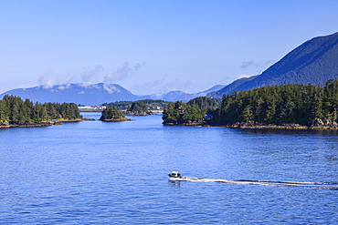 Boat travels through small forested islands, clearing morning mists, rare Summer sun, Sitka Sound, Sitka, Southeast Alaska, United States of America, North America