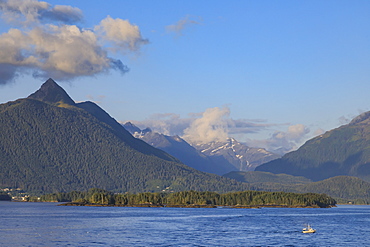 Commercial fishing vessel, forested snow-capped mountains, rare evening sun, Sitka Sound, off Baranof Island, Sitka, Alaska, United States of America, North America