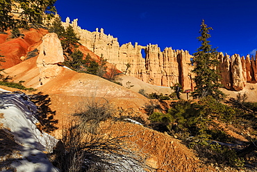 Wall of Windows lit by early morning sun, with snowy Peekaboo Loop Trail, Bryce Canyon National Park, Utah, USA