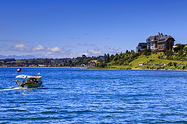 Excursion boat and wooded shoreline, Lake Llanquihue, downtown Puerto Varas, Lakes District, Chile, South America