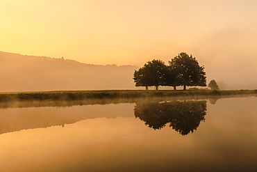 Reflections in River Derwent, dawn and autumn mist, Chatsworth Park, Peak District National Park, Chesterfield, Derbyshire, England, United Kingdom, Europe