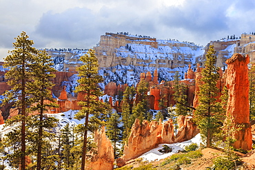 Hoodoos strongly lit by early morning sun with heavy cloud, Peekaboo Loop Trail in winter, Bryce Canyon National Park, Utah, United States of America, North America