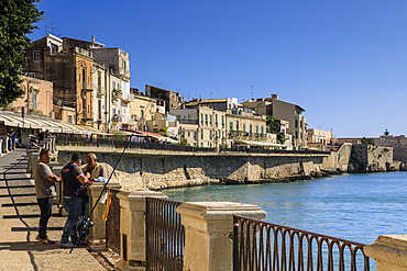 Fishermen deep in discussion, waterfront, Ortigia (Ortygia), Syracuse (Siracusa), UNESCO World Heritage Site, Sicily, Italy, Mediterranean, Europe