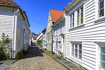 Beautiful old town, cobbled street, flowers and white wooden houses, blue sky in summer, Gamle Stavanger, Rogaland, Norway, Scandinavia, Europe