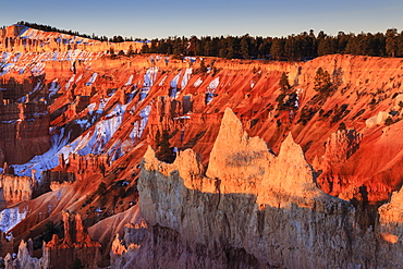 Hoodoos, rim and snow lit by strong dawn light, Queen's Garden Trail at Sunrise Point, Bryce Canyon National Park, Utah, United States of America, North America