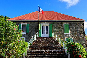 Old Swedish Jail, French flag, flowering shrubs, Gustavia, St. Barthelemy (St. Barts) (St. Barth), West Indies, Caribbean, Central America