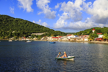 Deshaies waterfront, couple in rowing boat, Death In Paradise location, Saint Marie, Basse Terre, Guadeloupe, Leeward Islands, West Indies, Caribbean, Central America