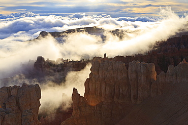 Fog and clouds of a partial temperature inversion surround the red rocks of Bryce Canyon, Bryce Canyon National Park, Utah, United States of America, North America 