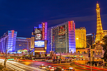 Neon lights on Las Vegas Strip at dusk with car headlights leaving streaks of light in front of Paris and Ballys, Las Vegas, Nevada, United States of America, North America 