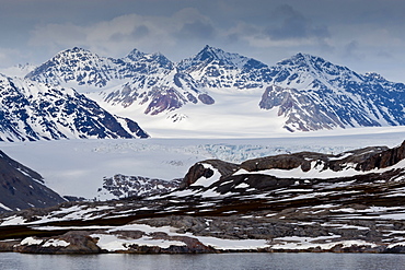 Glacier backed by snowy mountains, near Ny Alesund, Spitsbergen (Svalbard), Arctic, Norway, Scandinavia, Europe