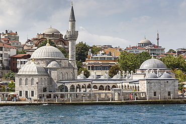 Couple walking past the Semsi Pasa Mosque, seen from the Bosphorus Strait, Uskudar, Istanbul, Turkey, Europe