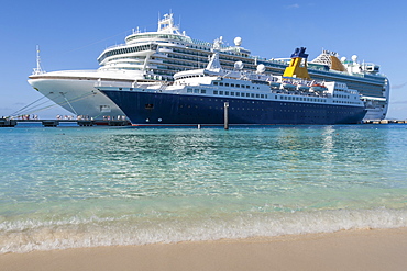 Cruise ships and disembarking passengers, seen from a white sand beach, cruise terminal; Grand Turk, Turks and Caicos, West Indies, Caribbean, Central America