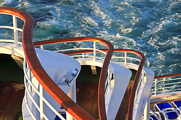 Sweeping tiers of wooden handrails at the stern of a cruise ship, lit by late evening sun, North Sea, off Norway, Scandinavia, Europe