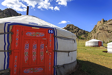 Tourist ger camp in front of rocky outcrop in fine weather in summer, Terelj National Park, Central Mongolia, Mongolia, Central Asia, Asia