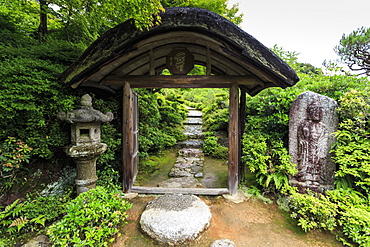 Okochi Sanso Villa, cobbled path through a wooden gateway in the verdant stroll garden in summer, Arashiyama, Kyoto, Japan, Asia