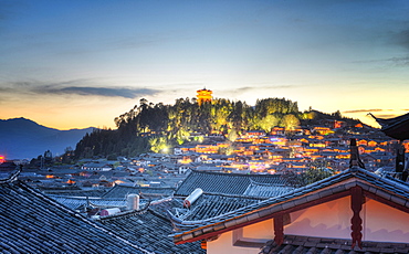 Night falls over Lijiang and Shizishan (Lion Hill with WanGu Tower) while the city lights slowly come to life, Lijiang, Yunnan, China, Asia 