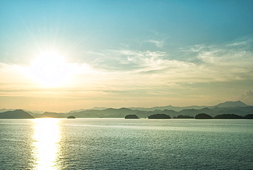 The sun about to set over the mountains surrounding Qiandao (Thousand Islands) Lake, Chunan, Zhejiang, China, Asia