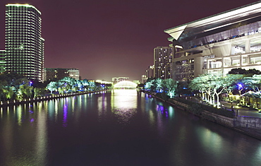 Illuminated architecture and reflections at night in Hangzhou City Center, Hangzhou, Zhejiang, China, Asia