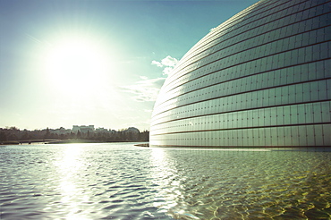 Sun and a partial view of Beijing Opera building with pool, Beijing, China, Asia