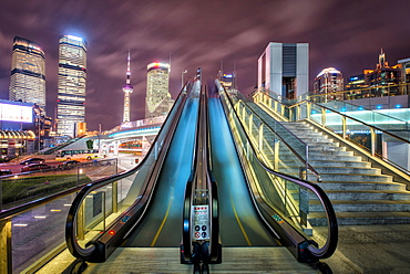 A modern, open-air escalator with Pudong cityscape at night, Shanghai, China, Asia