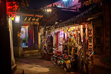 Alley at night with Tibetan style hostel and motorcycle in Lijiang Old Town, UNESCO World Heritage Site, Lijiang, Yunnan, China, Asia 