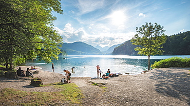 Lake Alpsee near Castle Neuschwanstein and Fuessen town with people enjoying leisure activities, Bavaria, Germany, Europe 