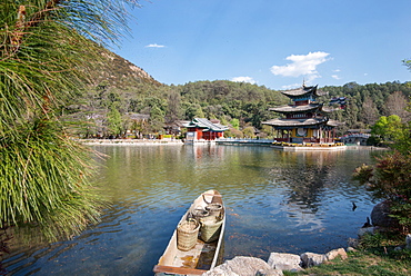 Scene at Black Dragon Pool (Heilongtan) with boat carrying wicker baskets and Moon Embracing Pavilion, Lijiang, Yunnan, China, Asia .