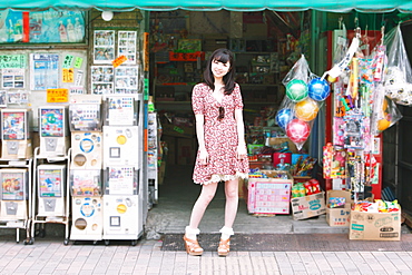 Japanese girl standing in front of an old candy shop